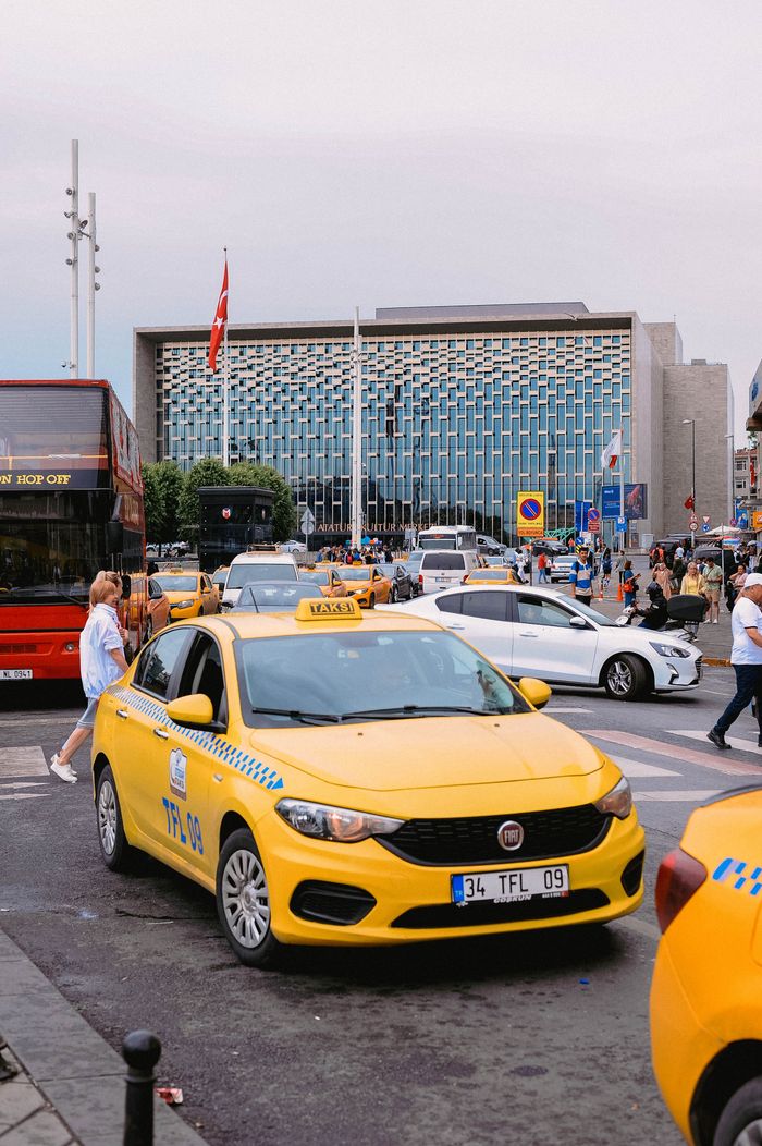 gallery-4 Yellow taxis and bustling street scene in front of a modern building in Istanbul, Turkey.