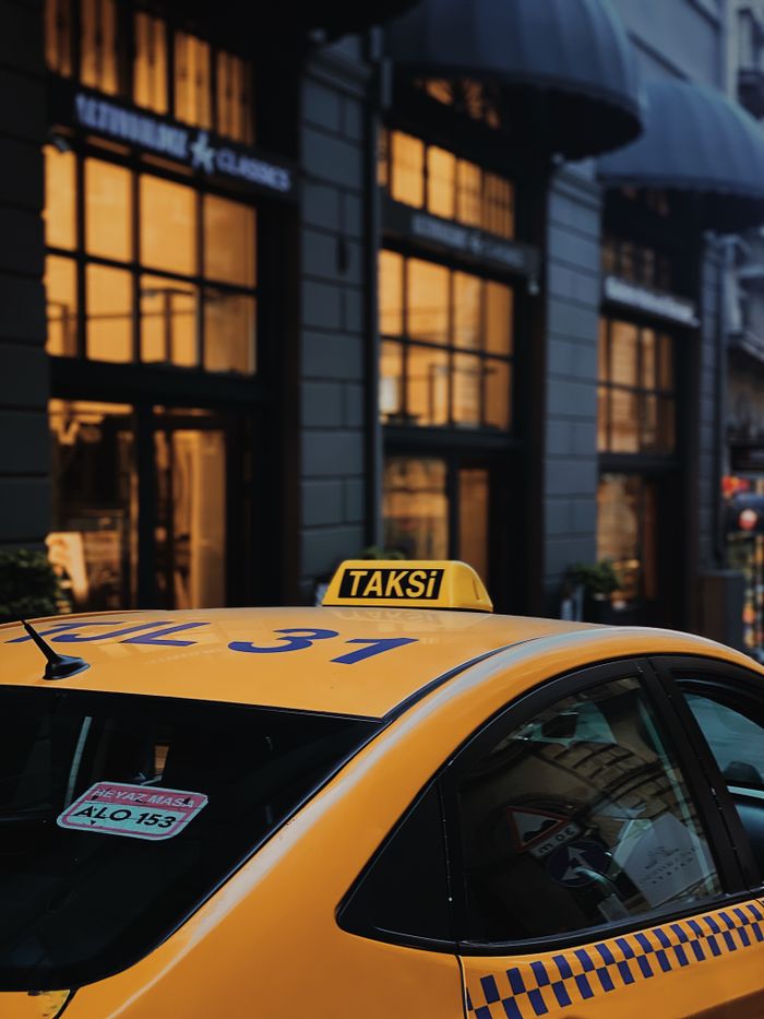 gallery-6 A yellow taxi parked on a lively street in Istanbul, capturing urban atmosphere.
